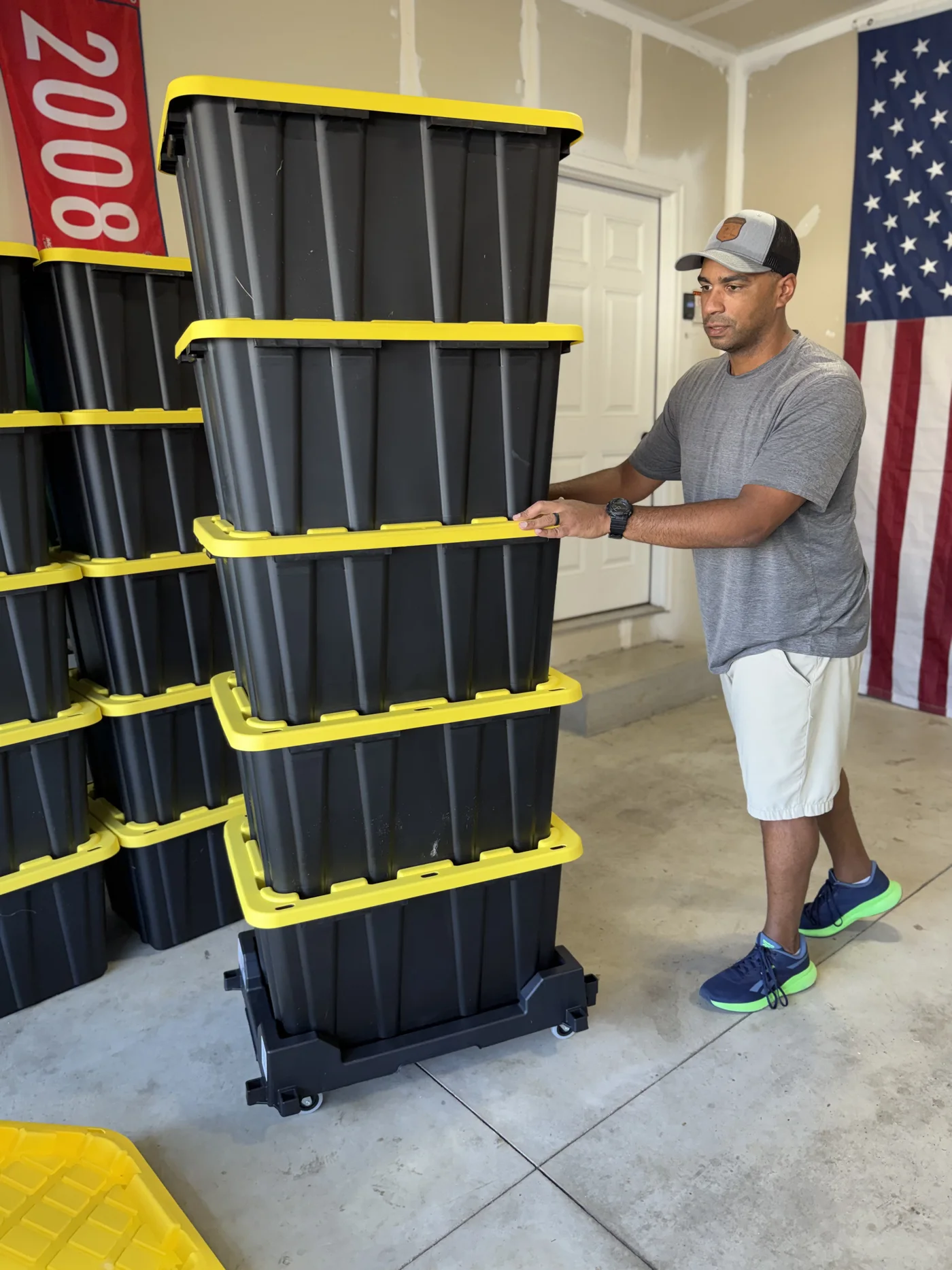 Tyler steadying a stack of closed moving totes on a tote dolly