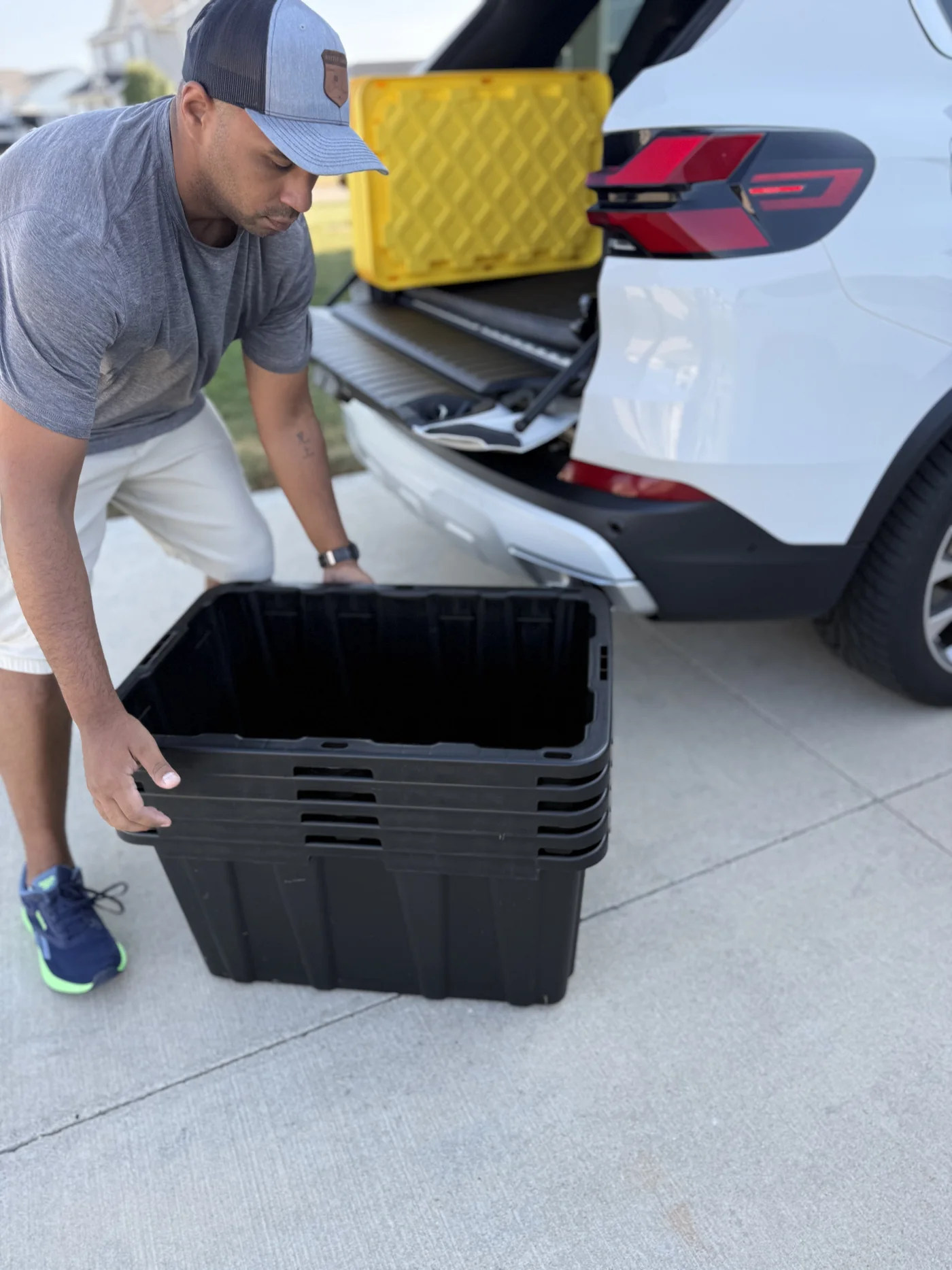 Tyler lifting an open stack of nested moving totes beside a delivery vehicle