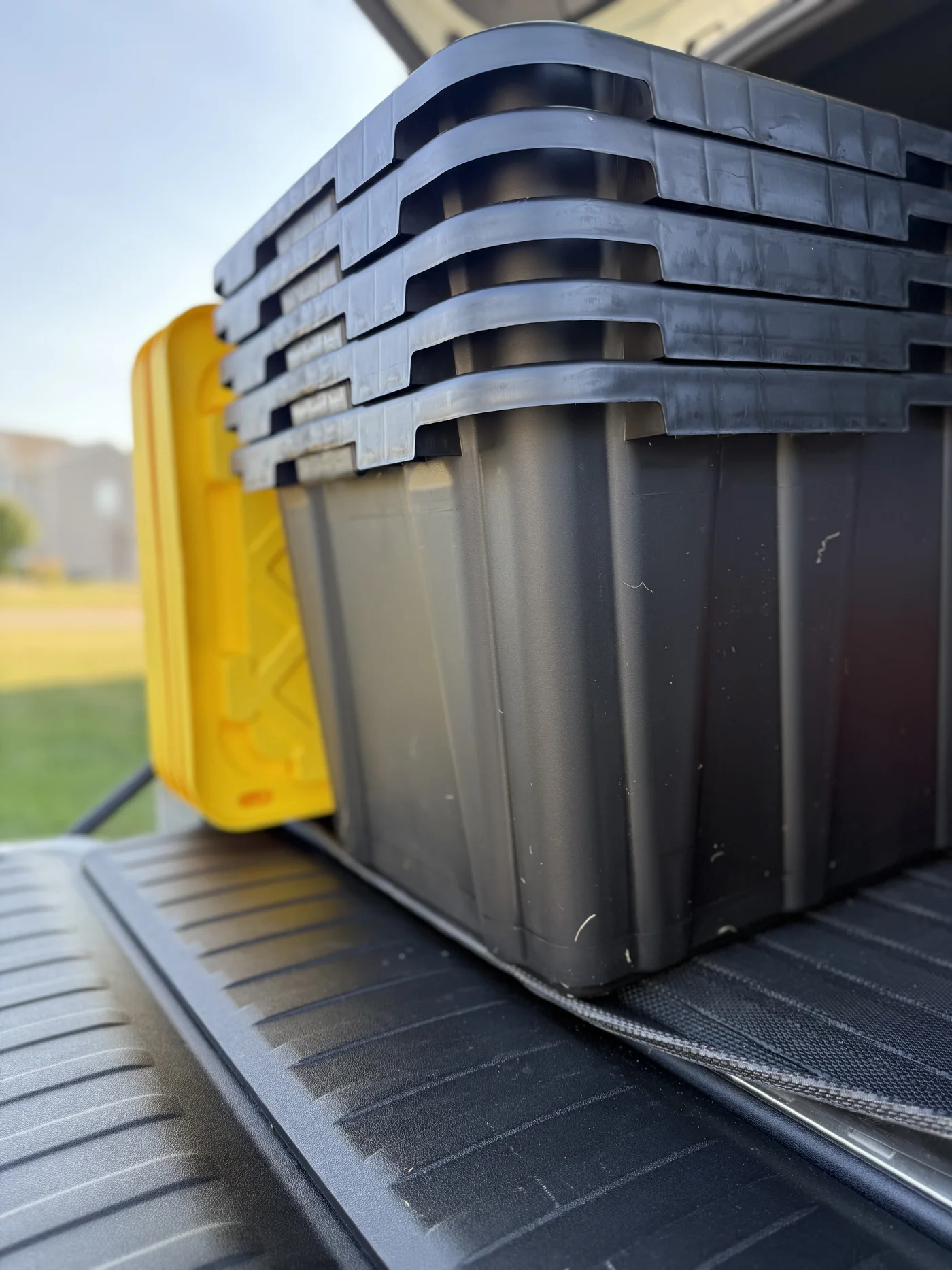 A close view of clean black moving totes nested tightly together
